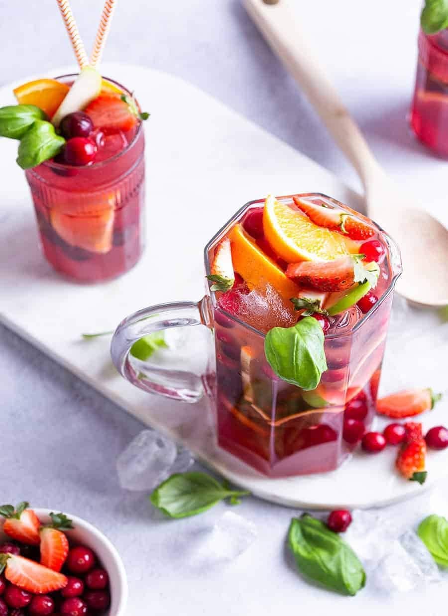 Sangria mocktail with cranberries, strawberries, basil and orange slices. 