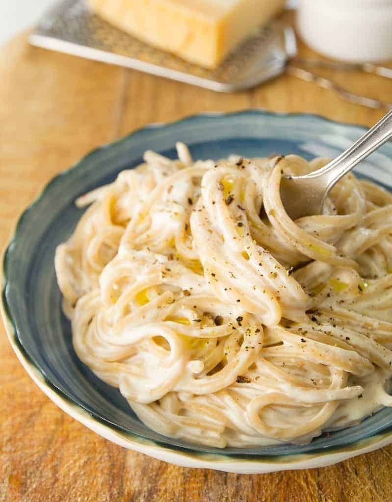 Pasta with cream cheese sauce garnished with peppers. 