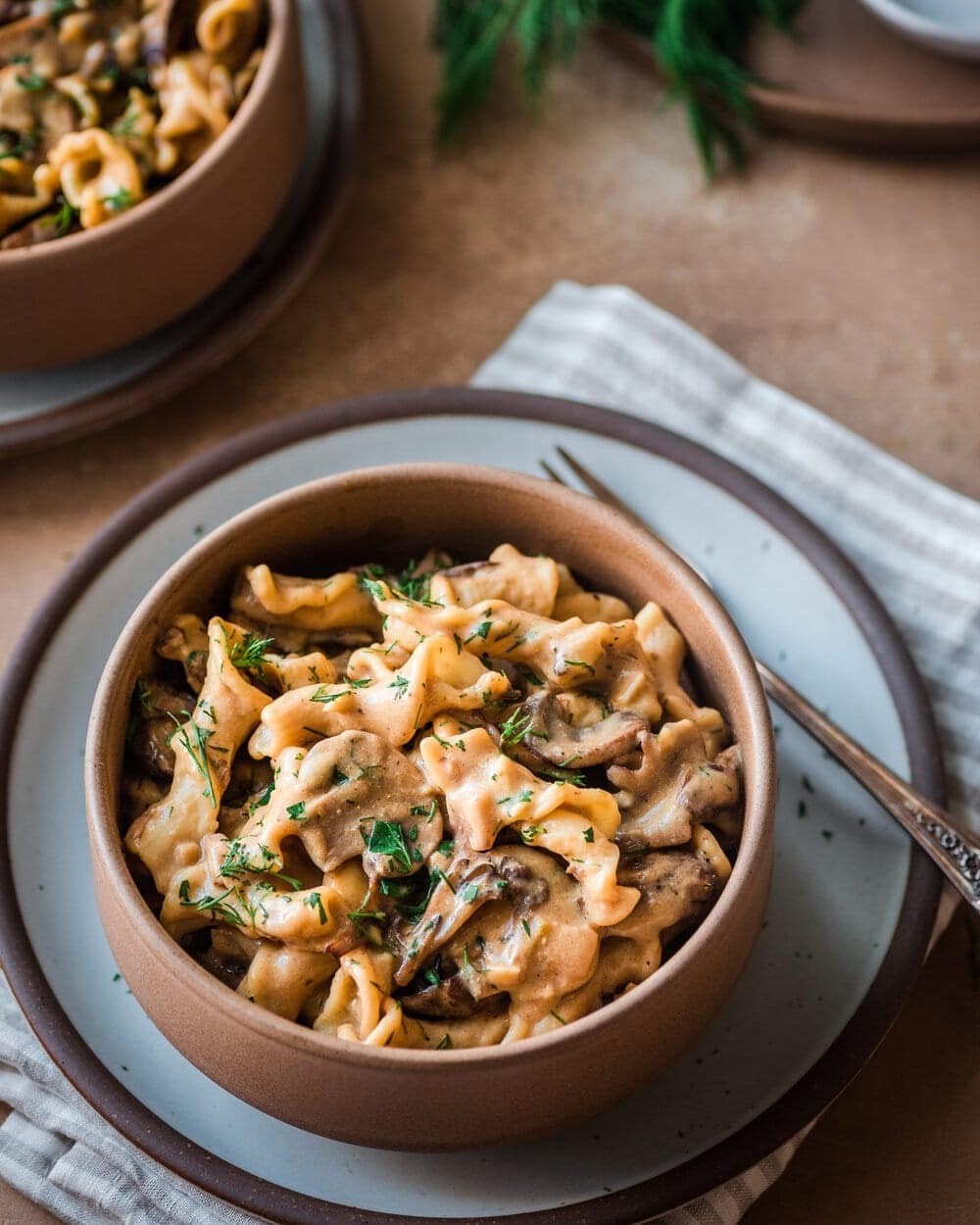 Mushroom stroganoff served on a brown bowl. 