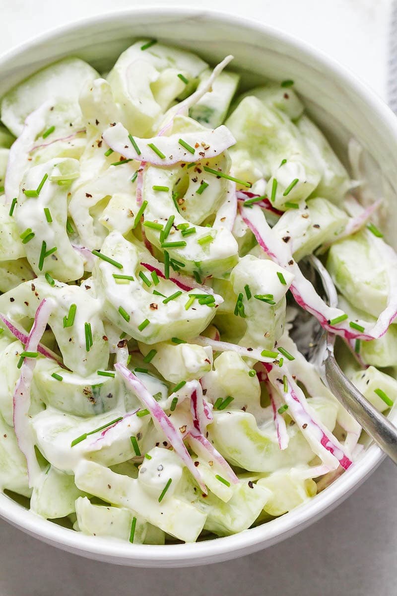 Cucumber salad with sliced onion and herbs.