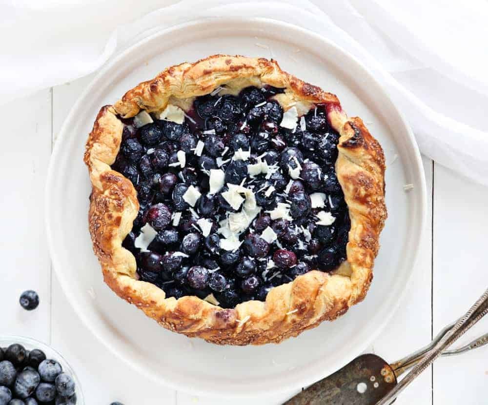 Top view of blueberry pie in a white plate. 