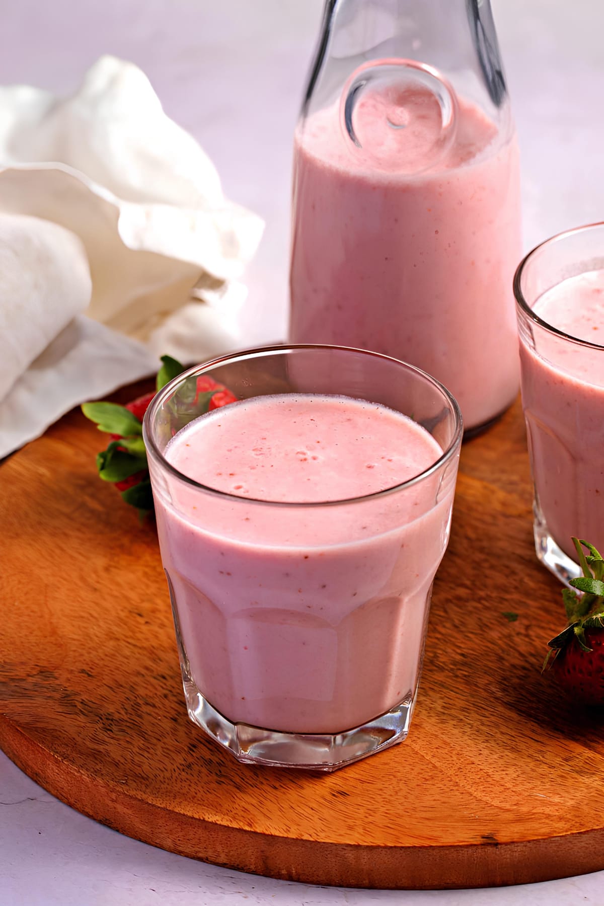 Strawberry milk on a glass and bottle.