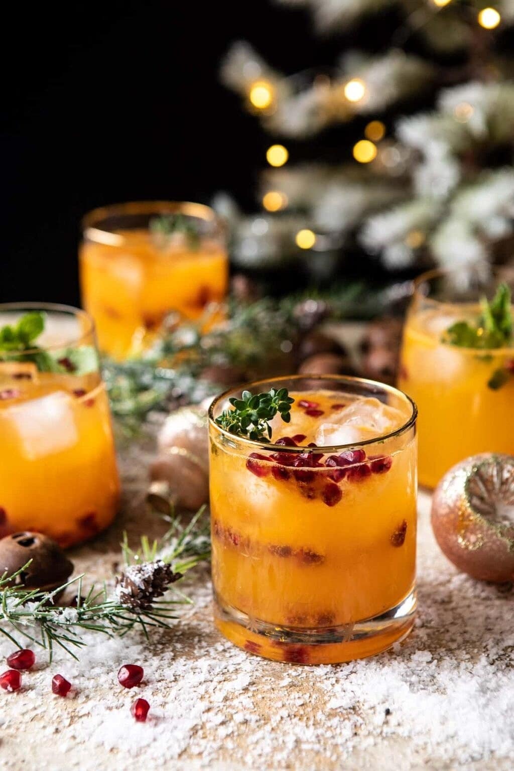 A glass of citrusy vodka cocktail garnished with pomegranate seeds.