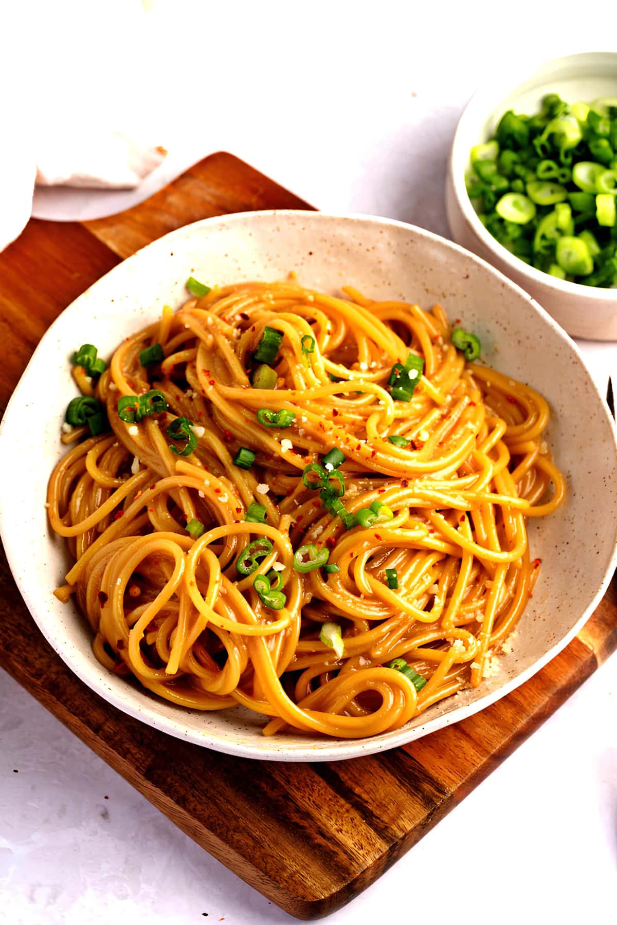 Homemade Spicy and Savory Garlic Noodles in a Bowl on a Wooden Board