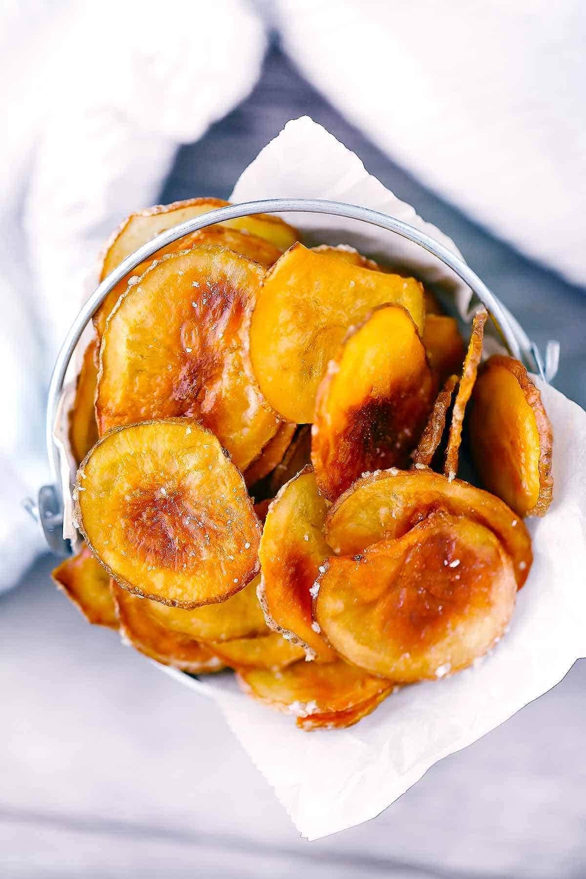 A bunch of thinly sliced potato chips on a bowl.