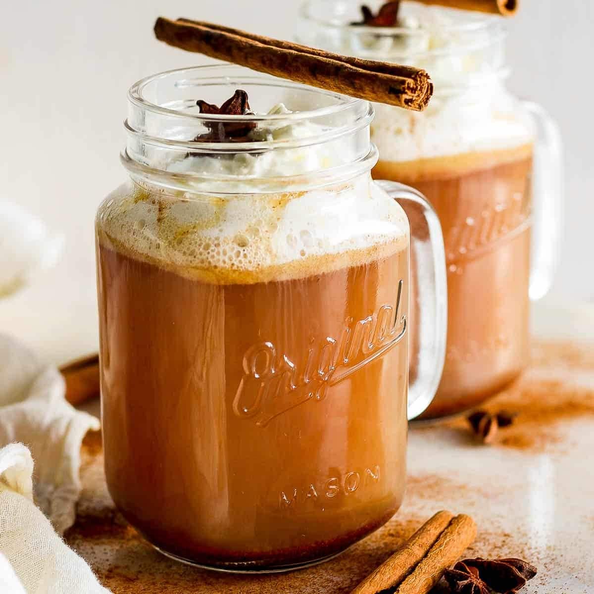 Cinnamon spice latte in a mason jar, topped with cinnamon.