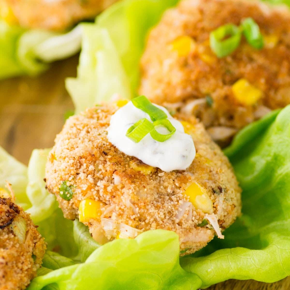 Crab cakes stuffed with jackfruit served on lettuce topped with cream.