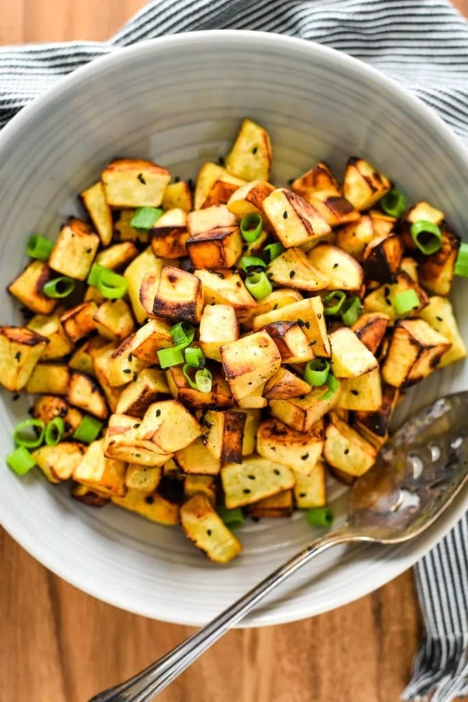 Homemade Japanese sweet potatoes with green onions and rice vinegar in a bowl with a spoon