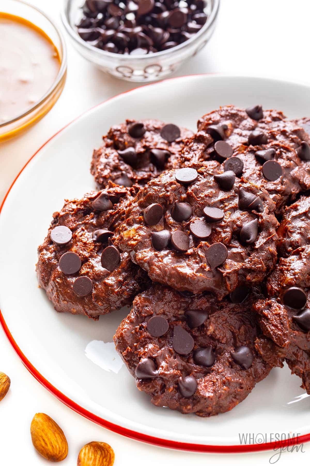 Bunch of unbaked peanut butter chocolate chip cookies on a white plate. 