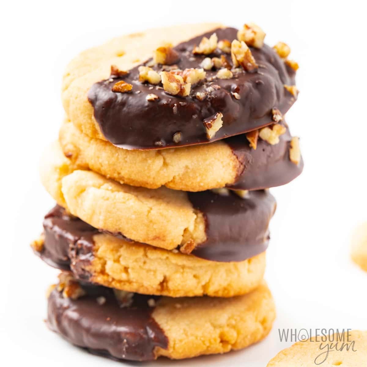 Stack of half coated shortbread cookies.