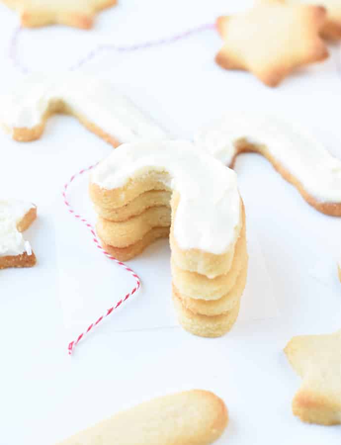 Stack of cut out cookies dusted with powdered sugar. 
