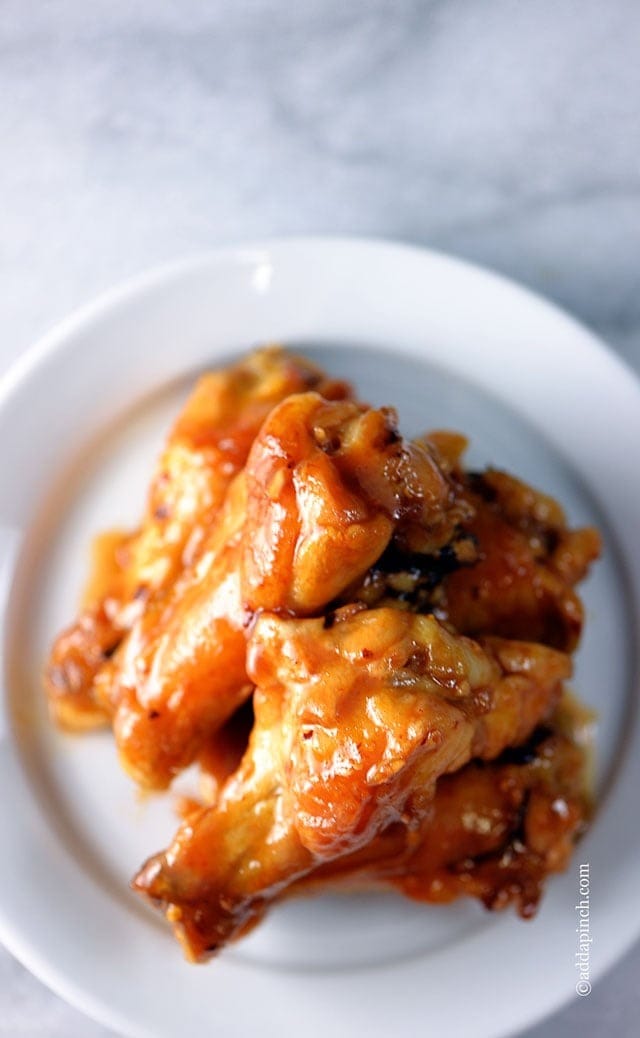 Top view of maple glazed chicken wings n a white plate. 