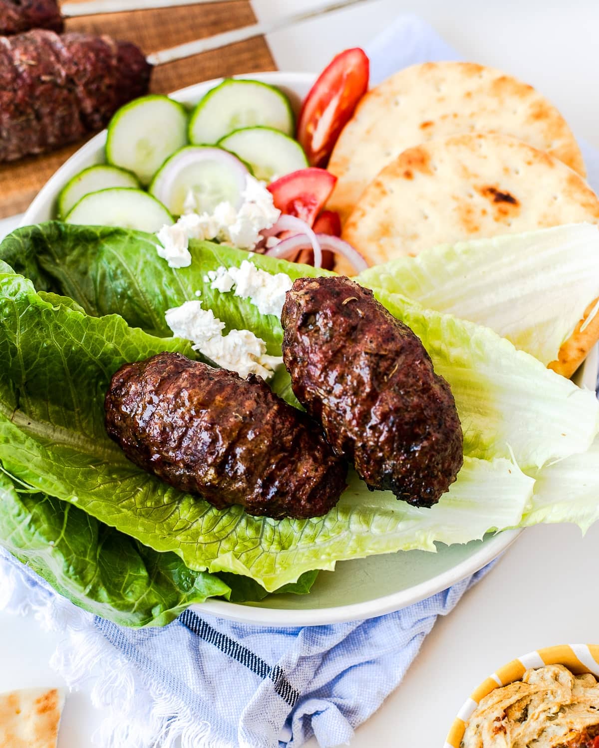 Mediterranean Beef Kabobs Served on Lettuce with Pita Bread, Tomatoes, Red Onions, Cucumbers, and Feta