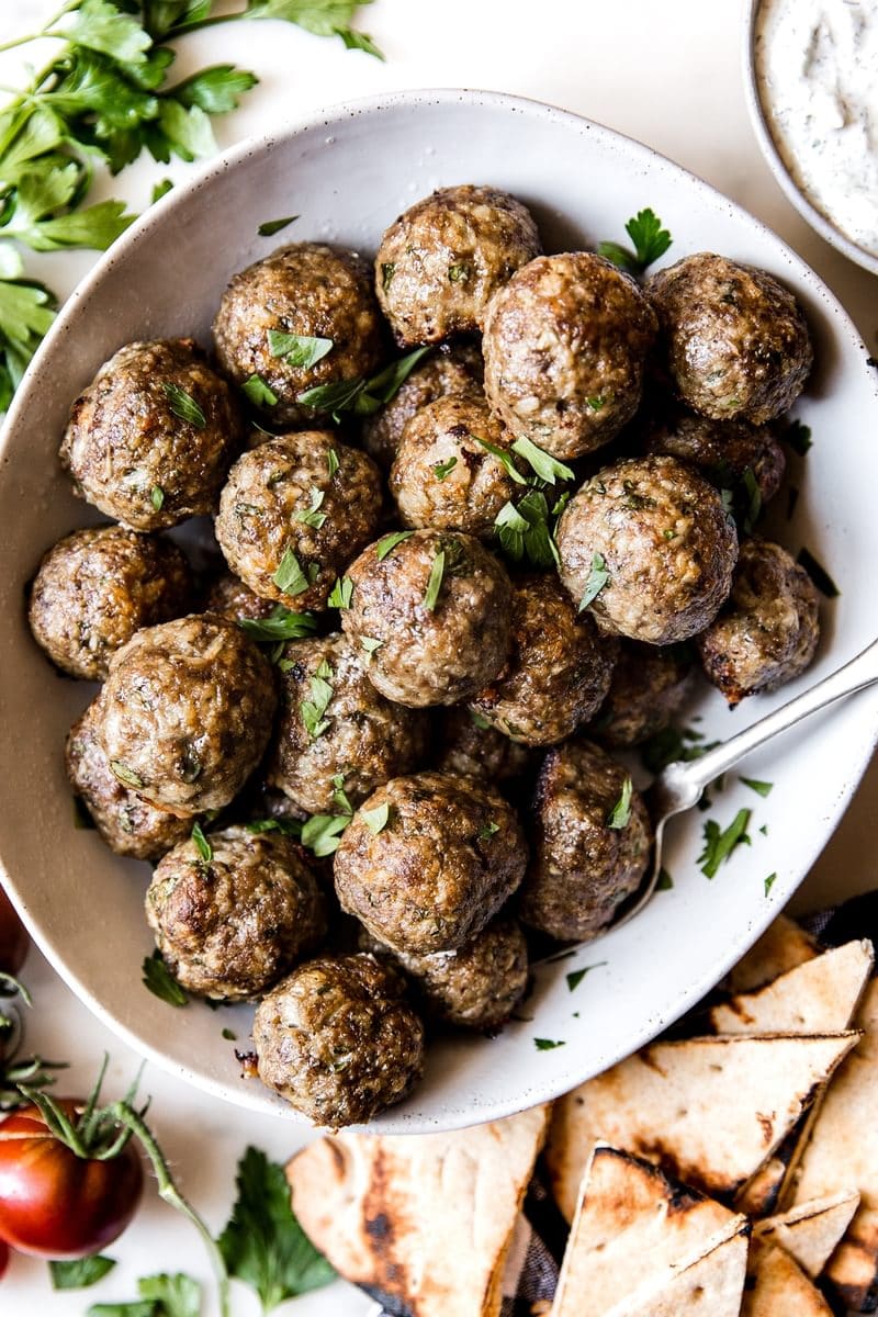 Flavorful Mediterranean Meatballs with Homemade Tzatziki, Topped with Parsley in a Bowl with a Spoon