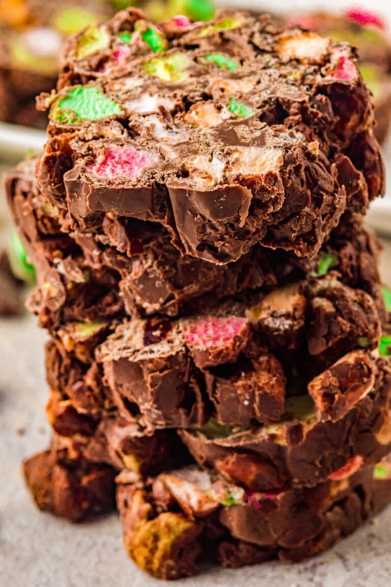 A pile of stained glass cookies made with melted chocolate, mini marshmallows, dried cherries, and Rice Krispies. 