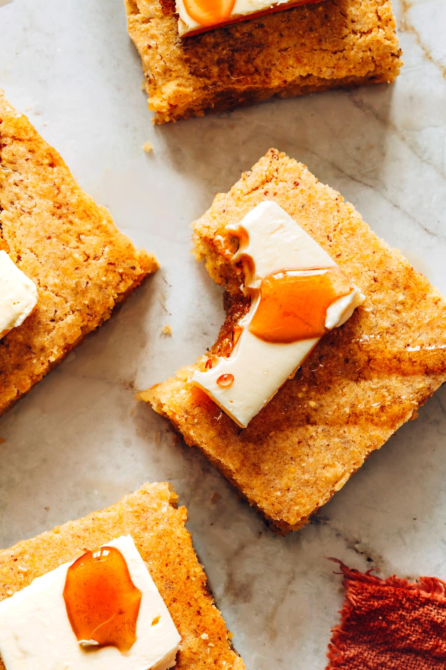 Sliced cornbread with butter on top.