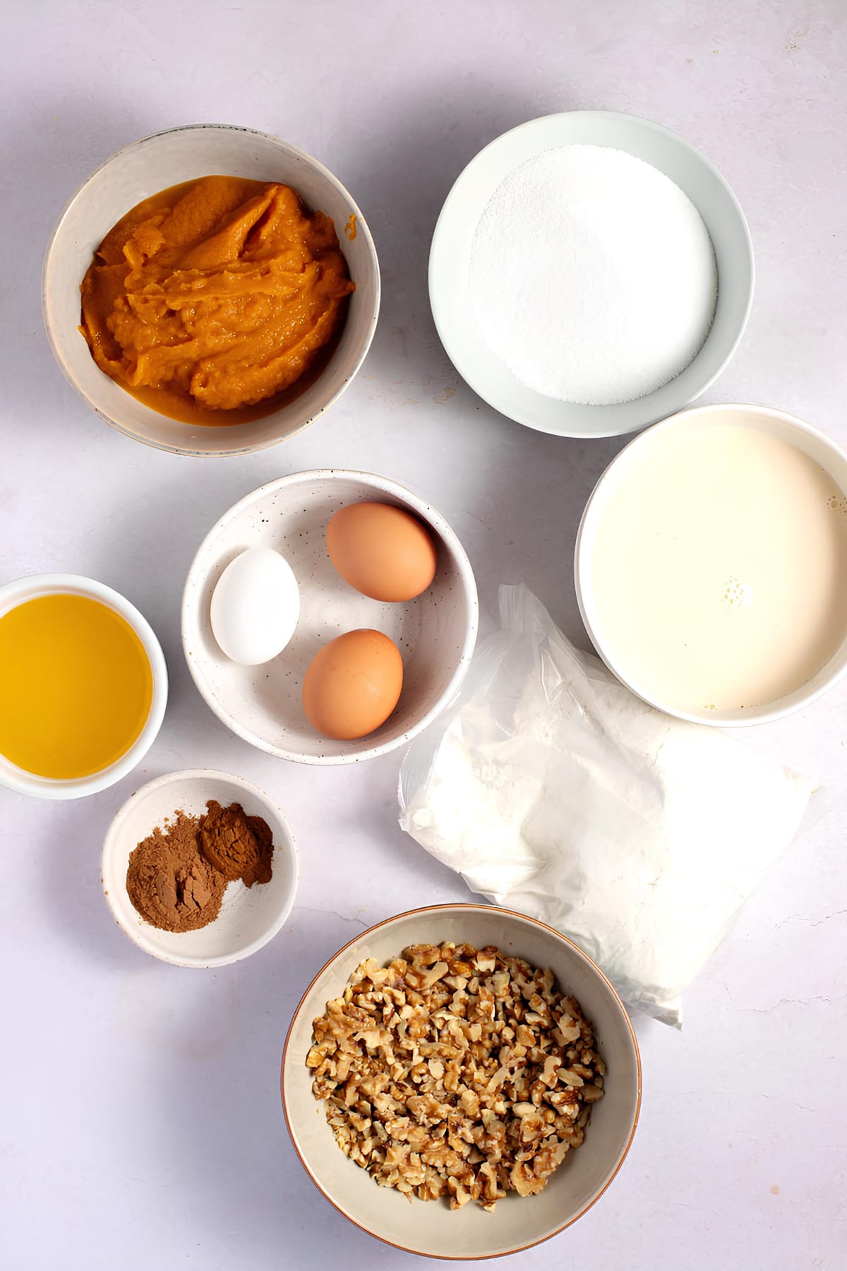 Pumpkin Dessert With Yellow Cake Mix Ingredients: Eggs, pumpkin puree, milk, sugar and spices on top of table. 