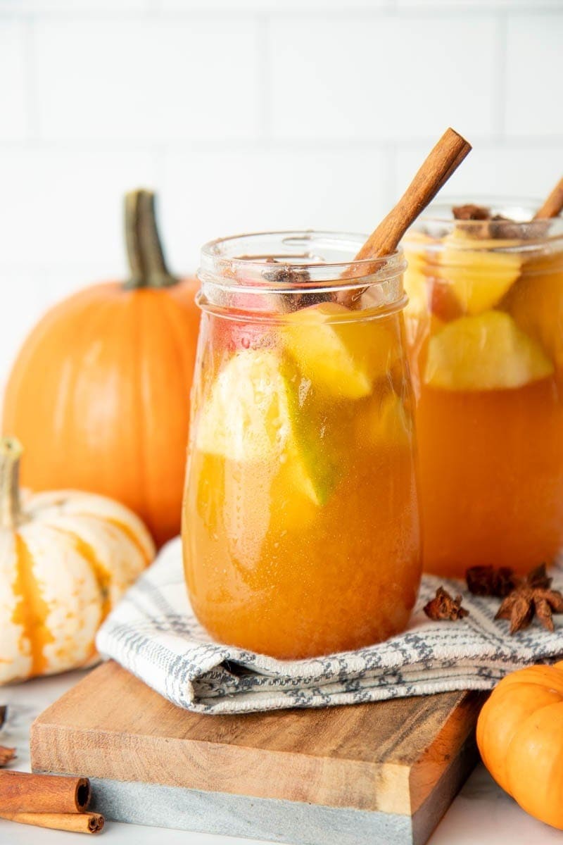 Pumpkin spice sangria on glasses garnished with chopped apples, pears, star anise and cinnamon stick. 