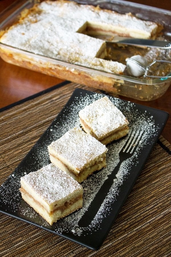 Romanian apple pie cake slices sprinkled with powdered sugar.