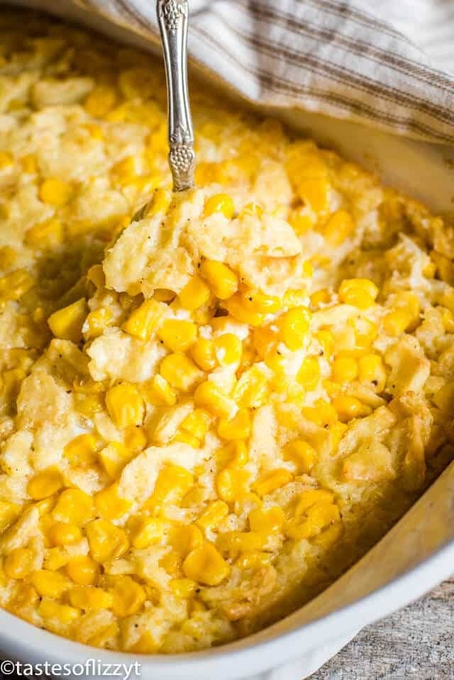 Cheesy scalloped corn casserole on a white dish. 