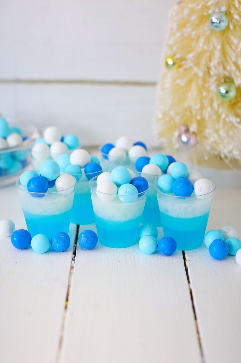 Blue Jello shots on shot glasses garnished with M&M snowball candies. 
