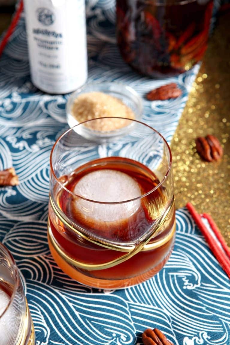 A refreshing cocktail with whiskey, ice, and pecans.