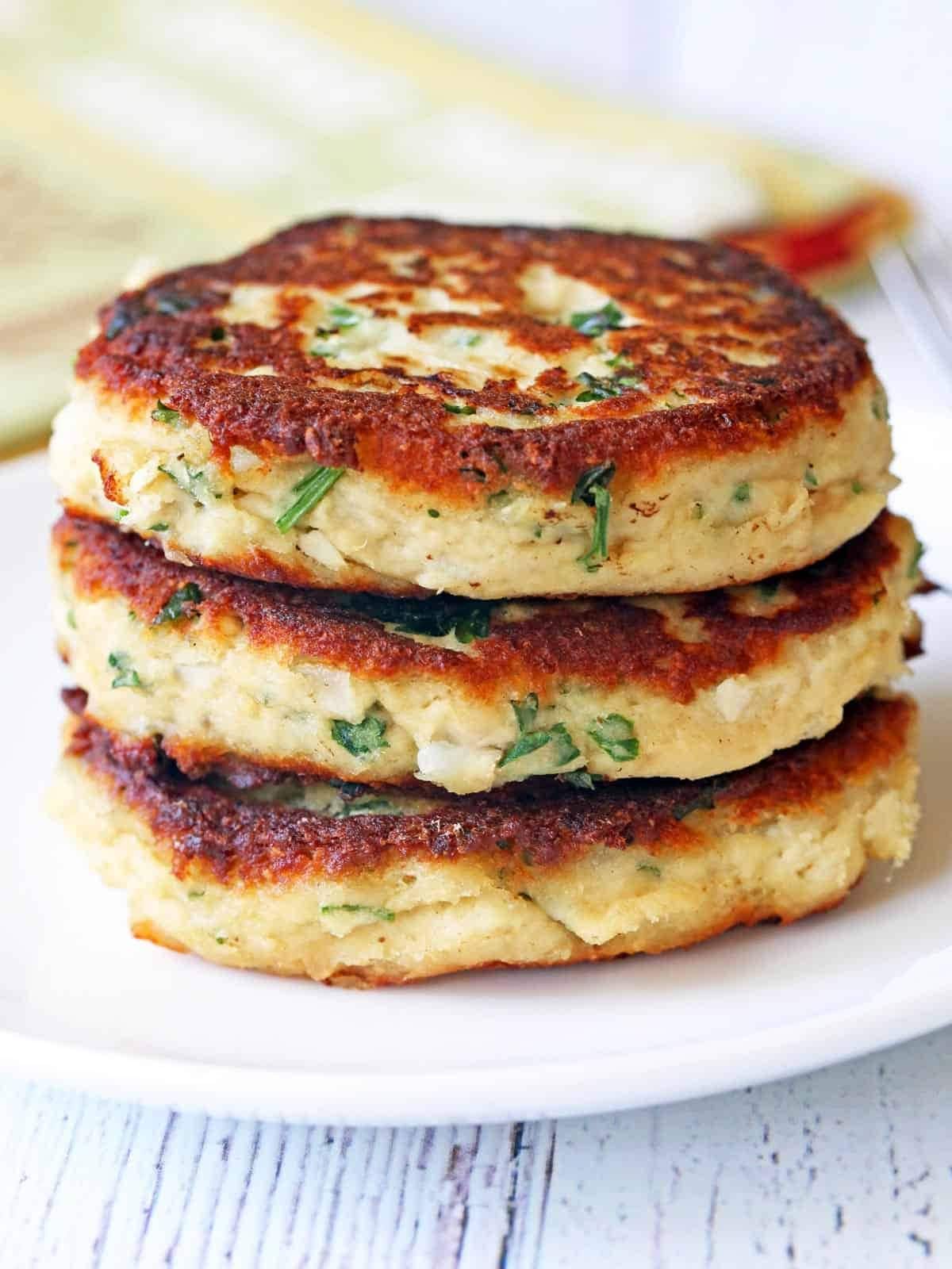 Turkey patties stack over each other on a white plate. 