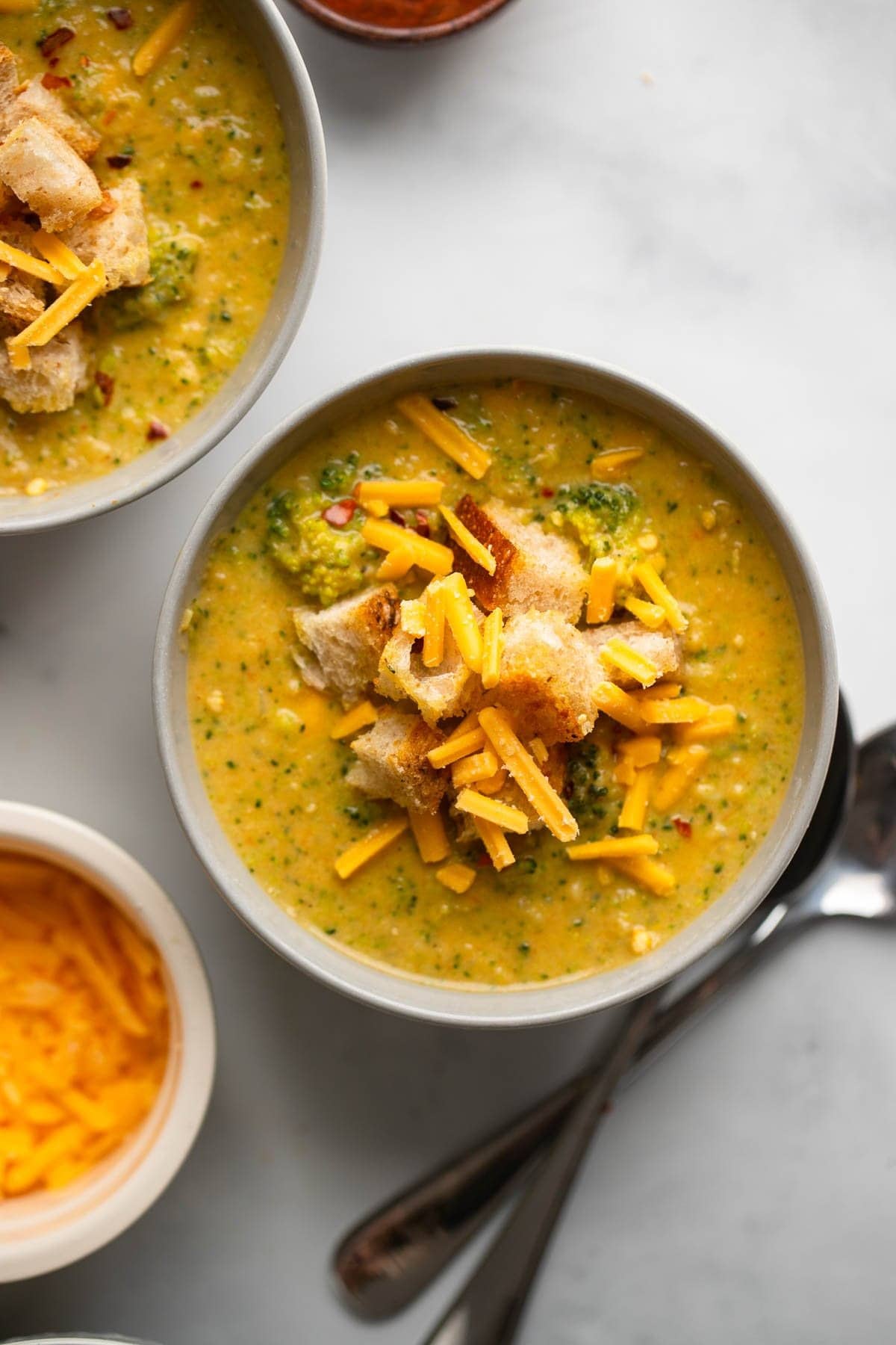 Vegan broccoli cheddar soup with croutons  in a bowl- top view