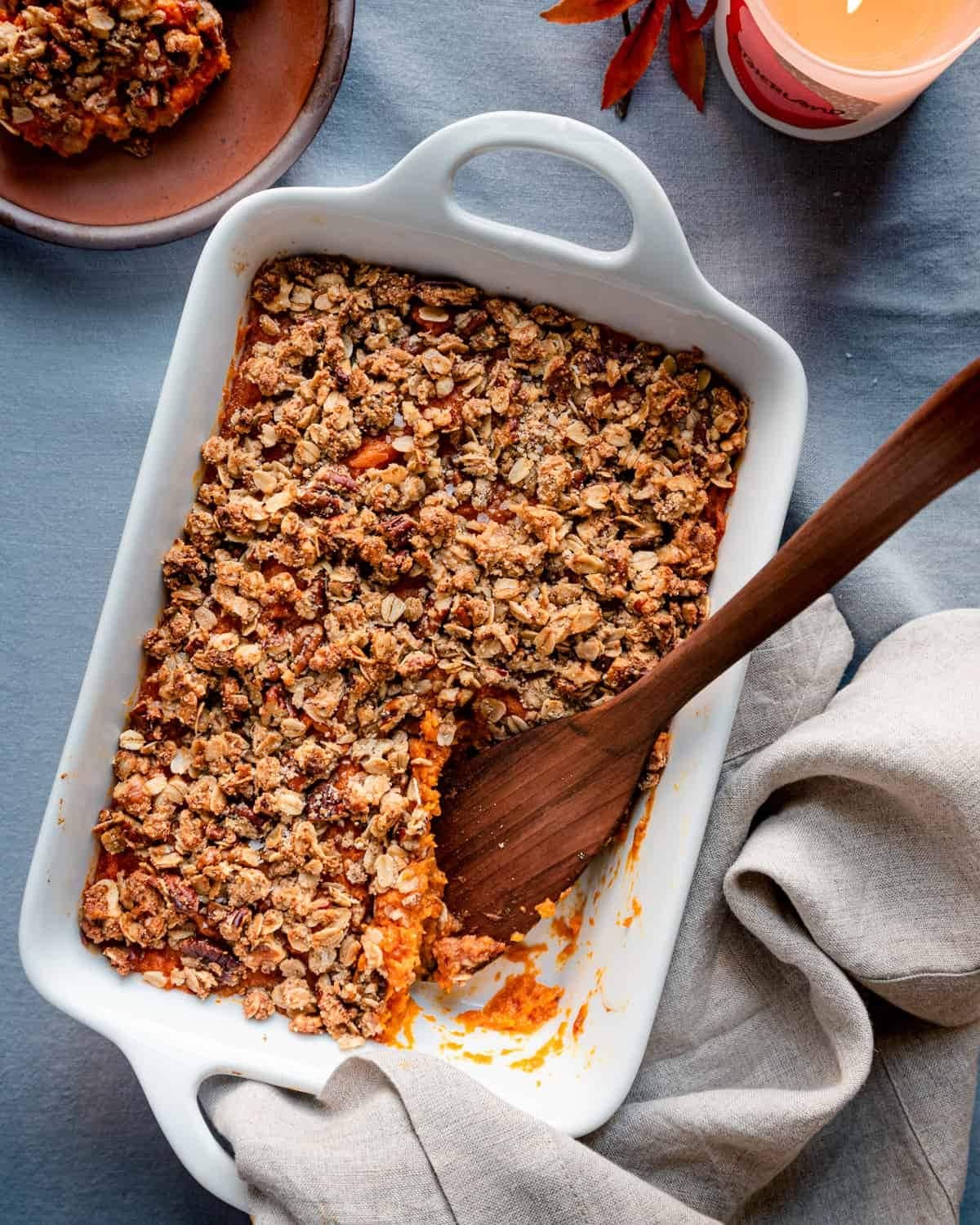 Sweet potato casserole in a baking dish with crumbly toppings.