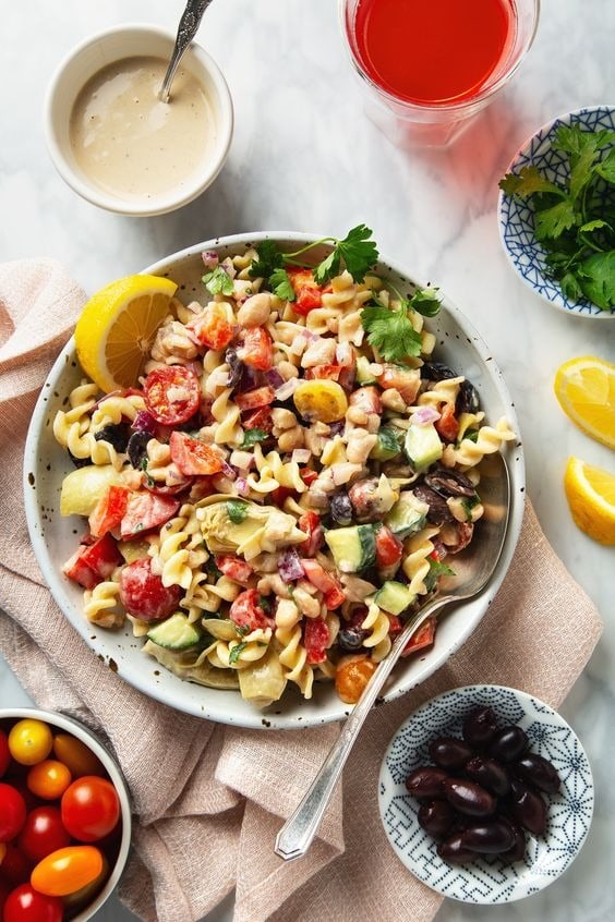 Pasta salad with eans, artichoke hearts, cucumbers, peppers, onions, tomatoes and olives.