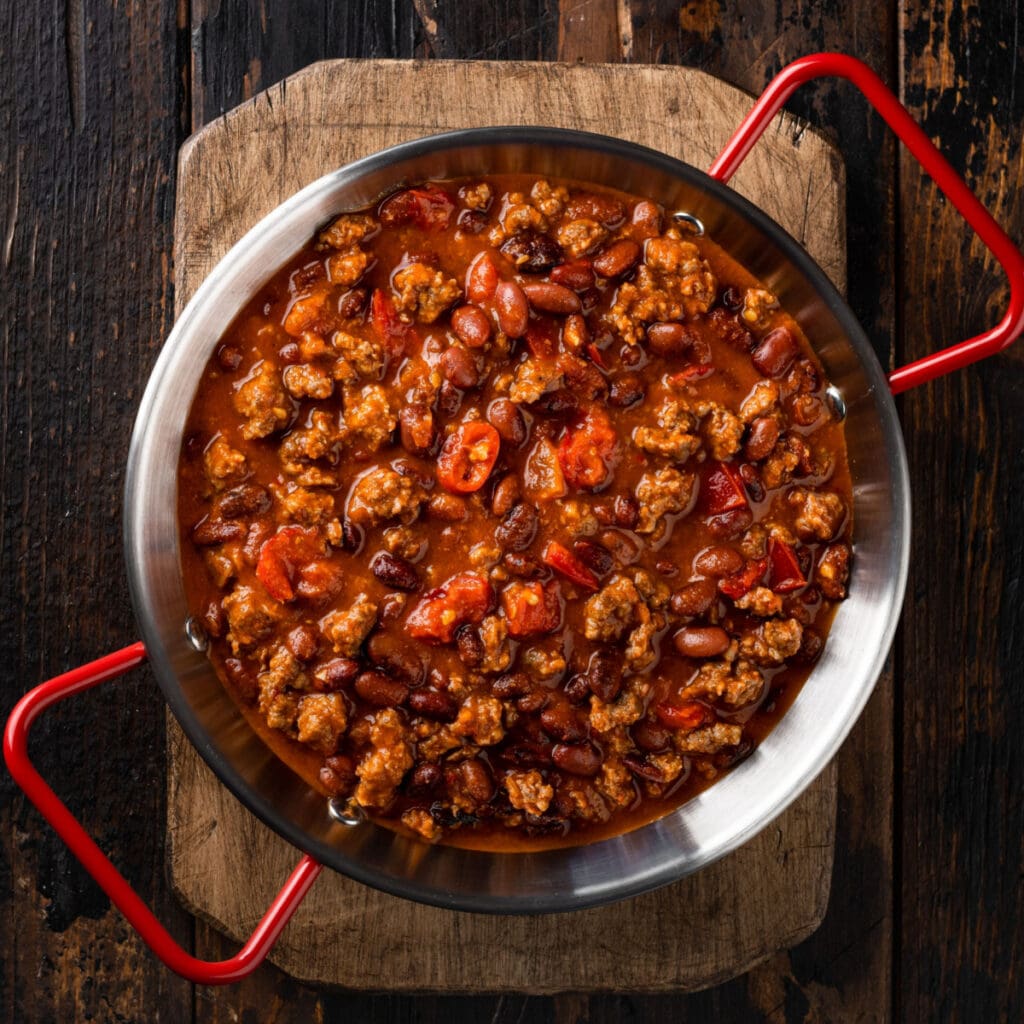 Topped view of cooked chili in stainless steel wok. 