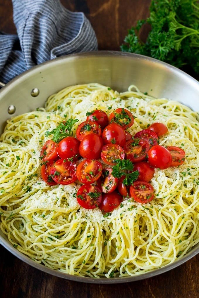 Angel hair pasta with garlic and herbs topped with fresh red tomatoes