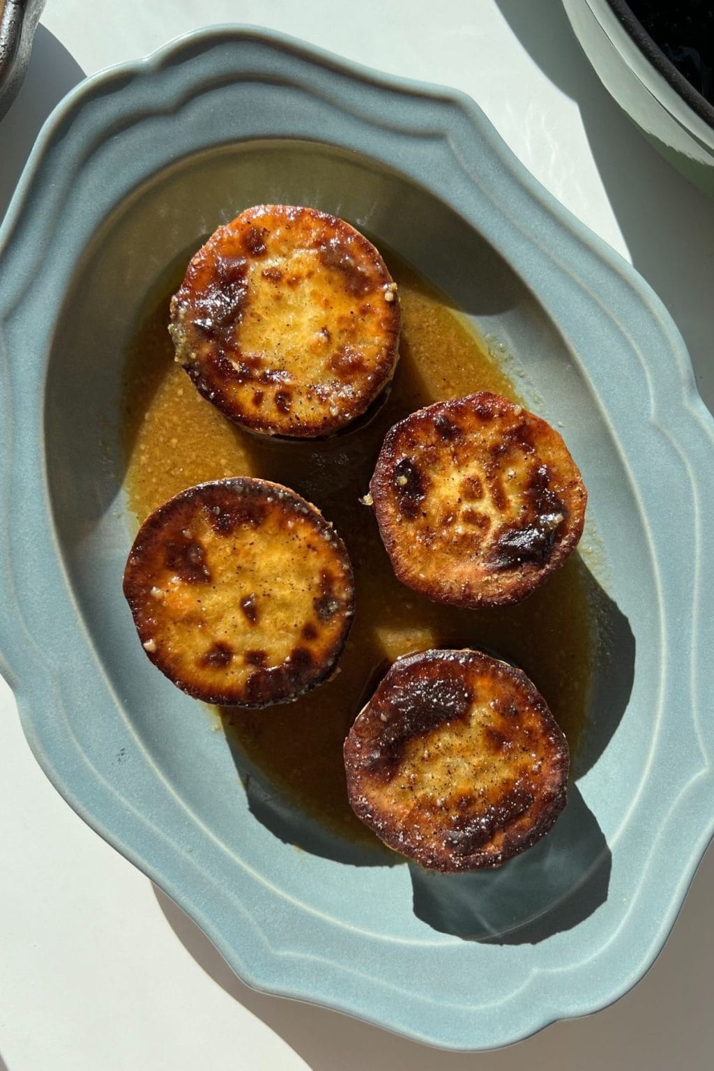 Crispy fondant Japanese sweet potato rounds on a blue serving platter