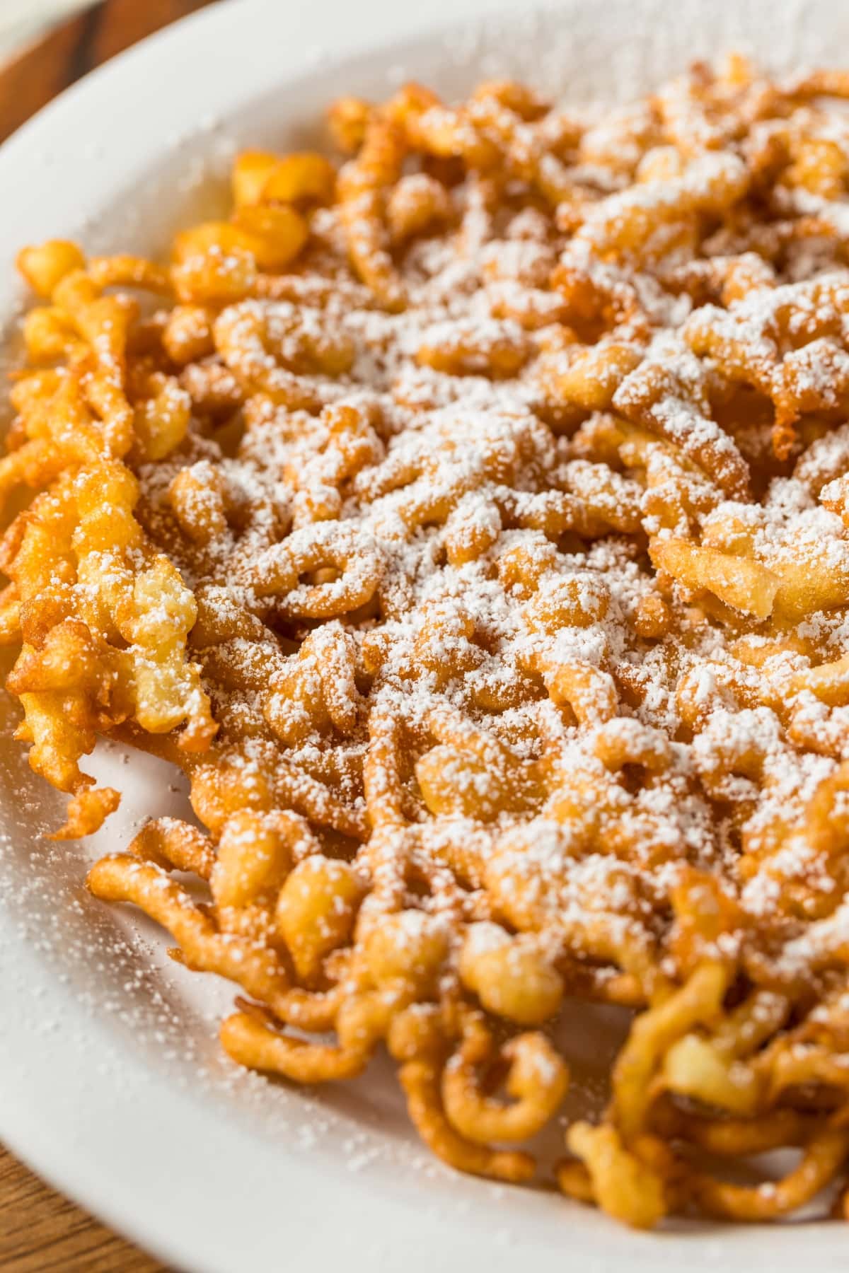 Cake funnel on a white plate sprinkled with powdered sugar on top.