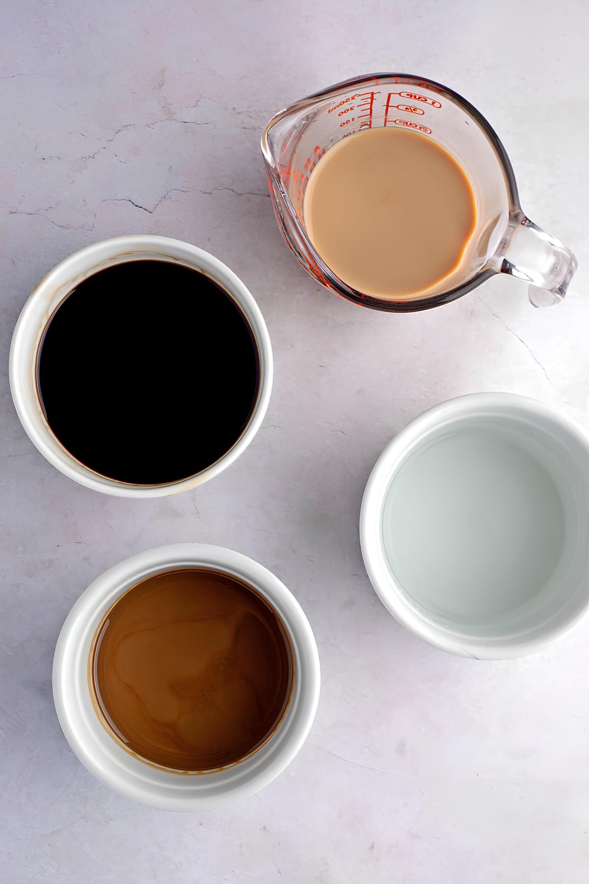 Portion serving of chocolate syrup, vodka, creme de cacao and Bailey's irish cream on bowls. 