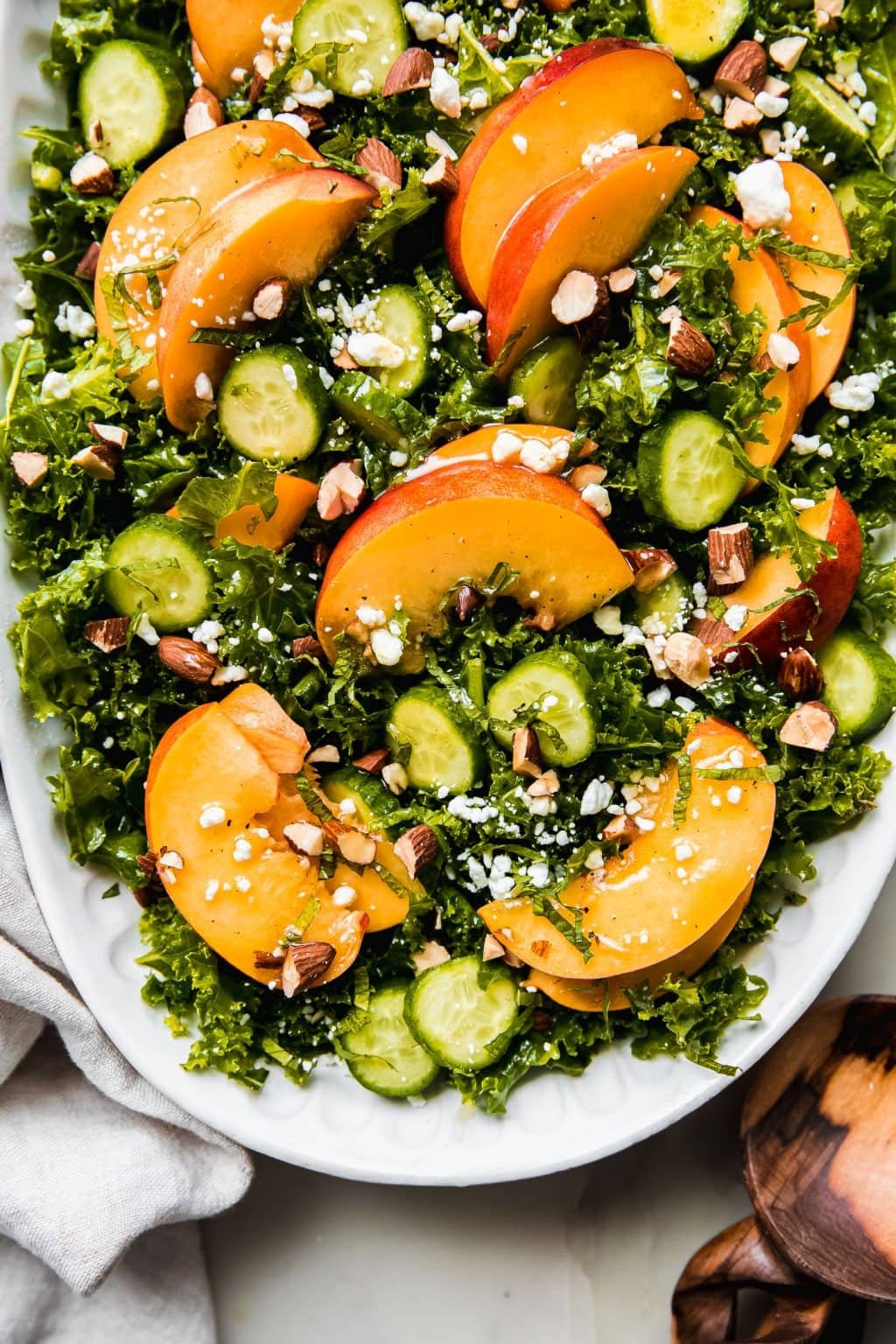 Sweet peach salad with goat cheese, cucumbers, goat cheese, and toasted almonds over fresh greens.