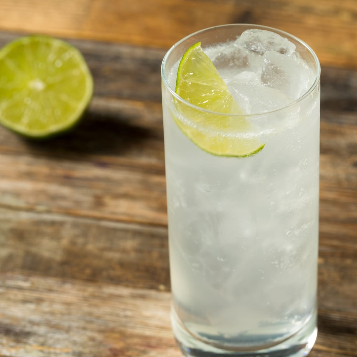 Ranch water cocktail served with ice on a highball glass garnished with lime slice. 