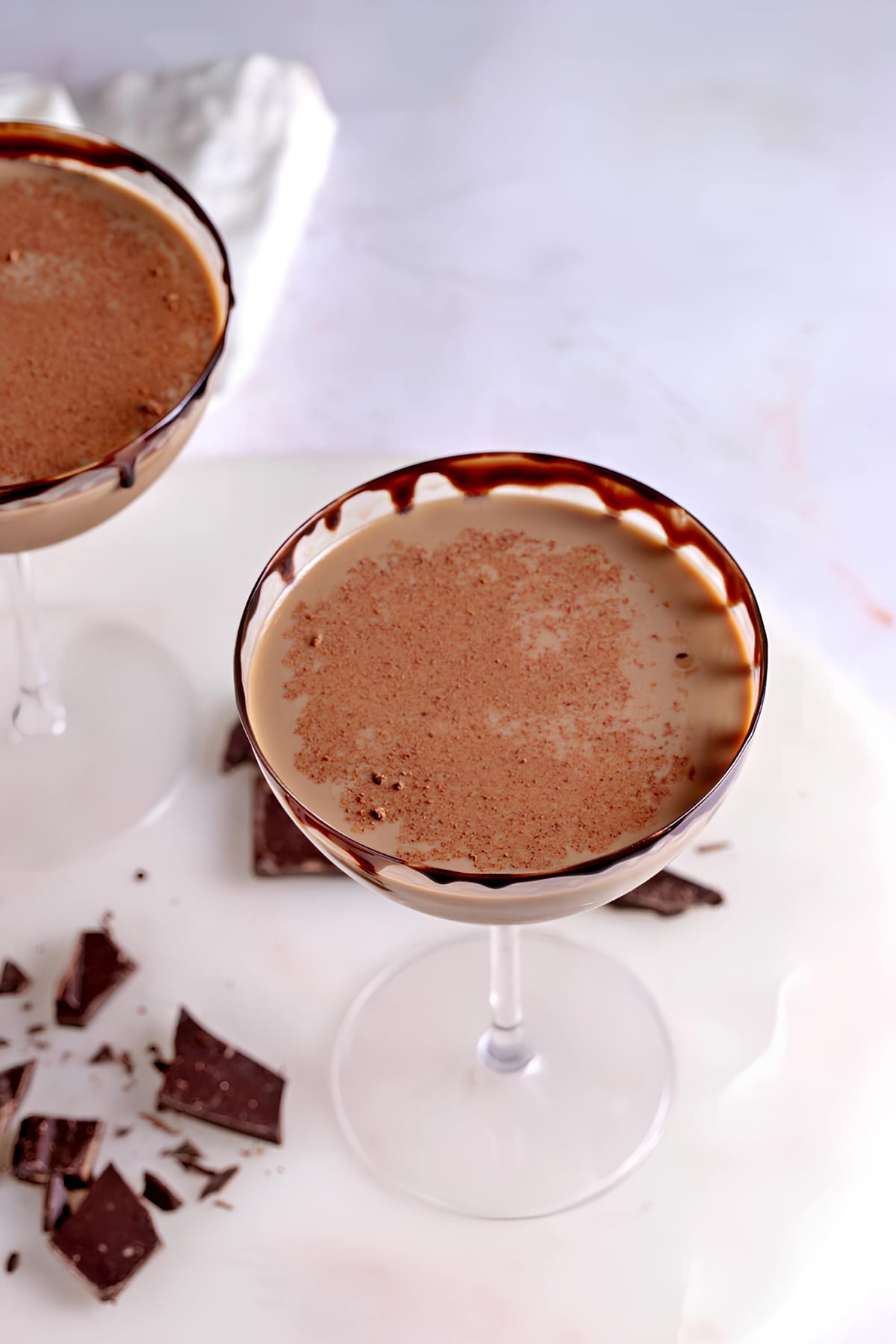 Top view of chocolate martini served on chocolate syrup rimmed cocktail glass. 