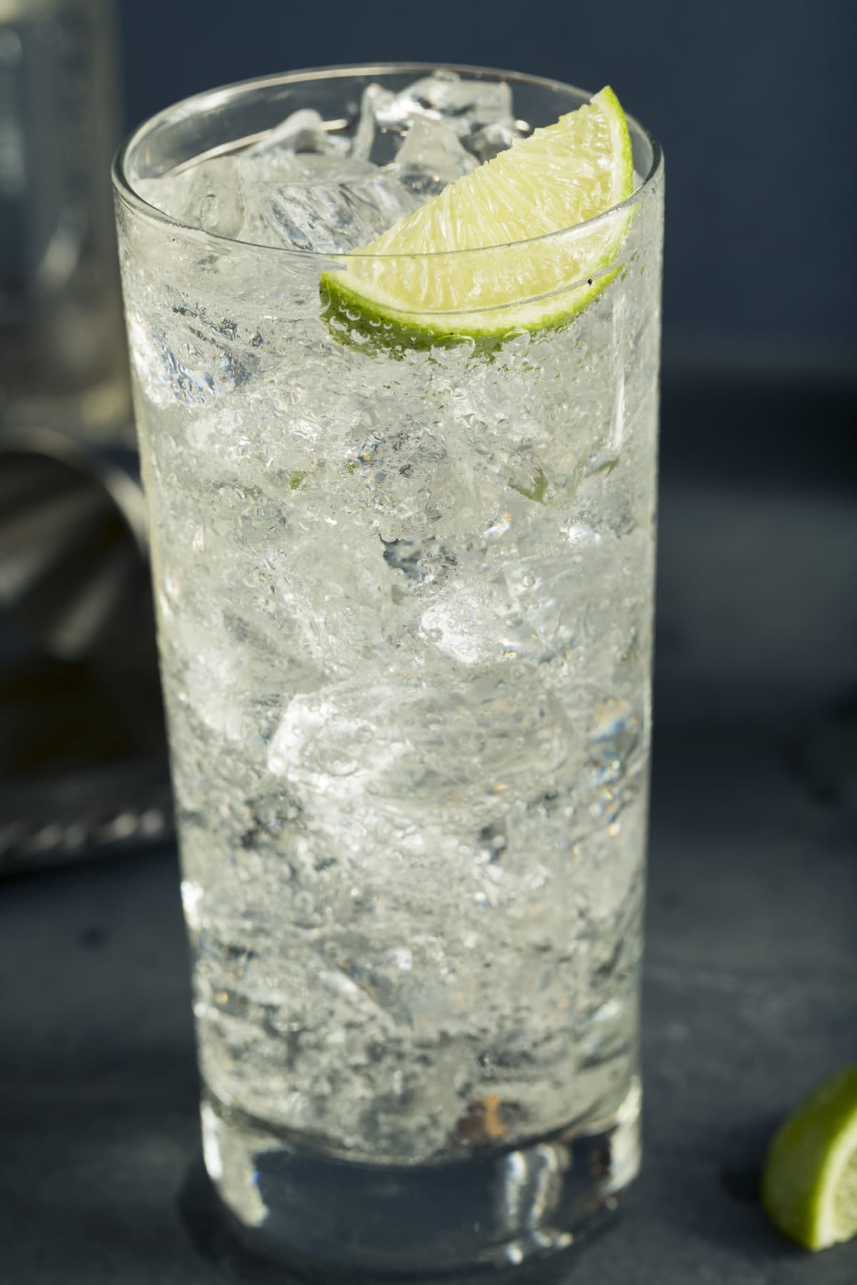 Sparkling vodka soda served on a tall glass filled with ice garnished with lemon slice. 