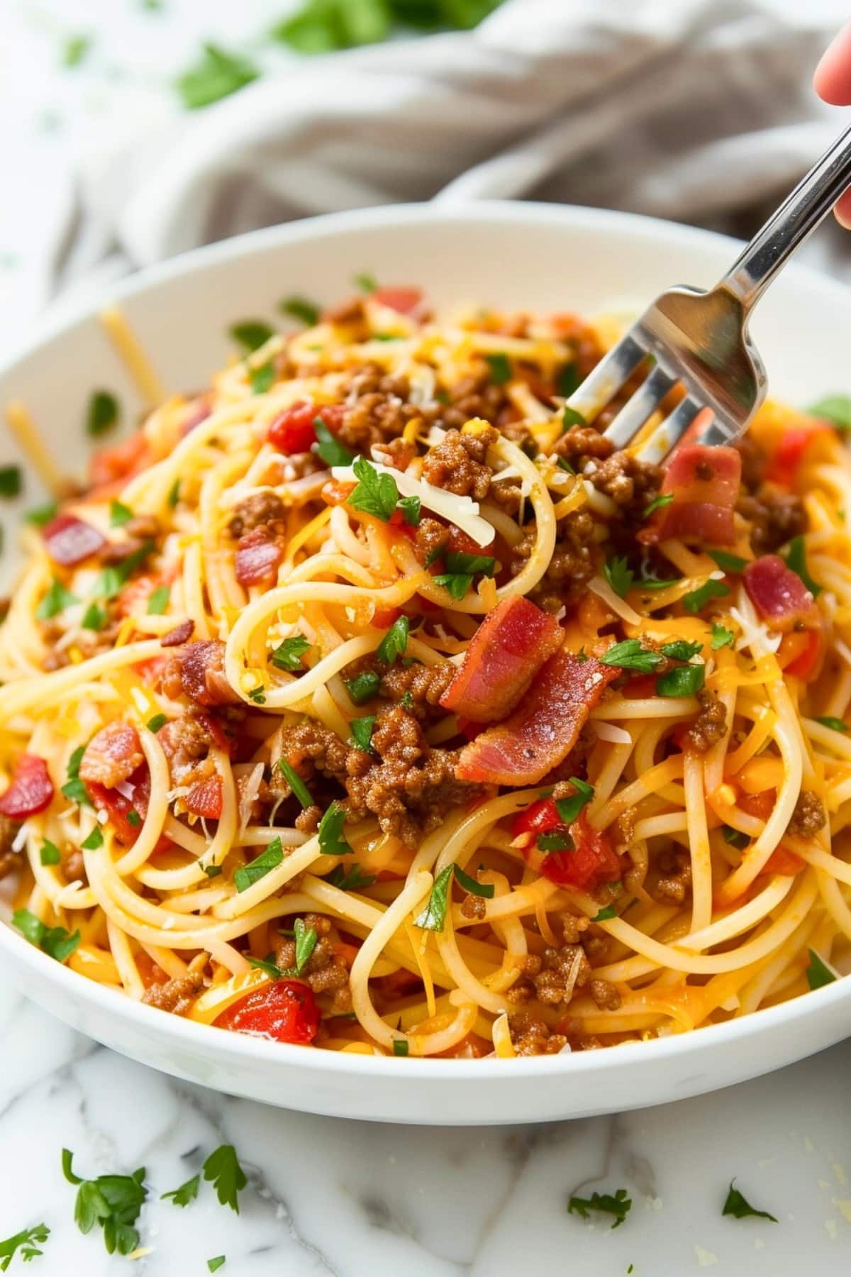 Fork scooping cowboy spaghetti from a bowl
