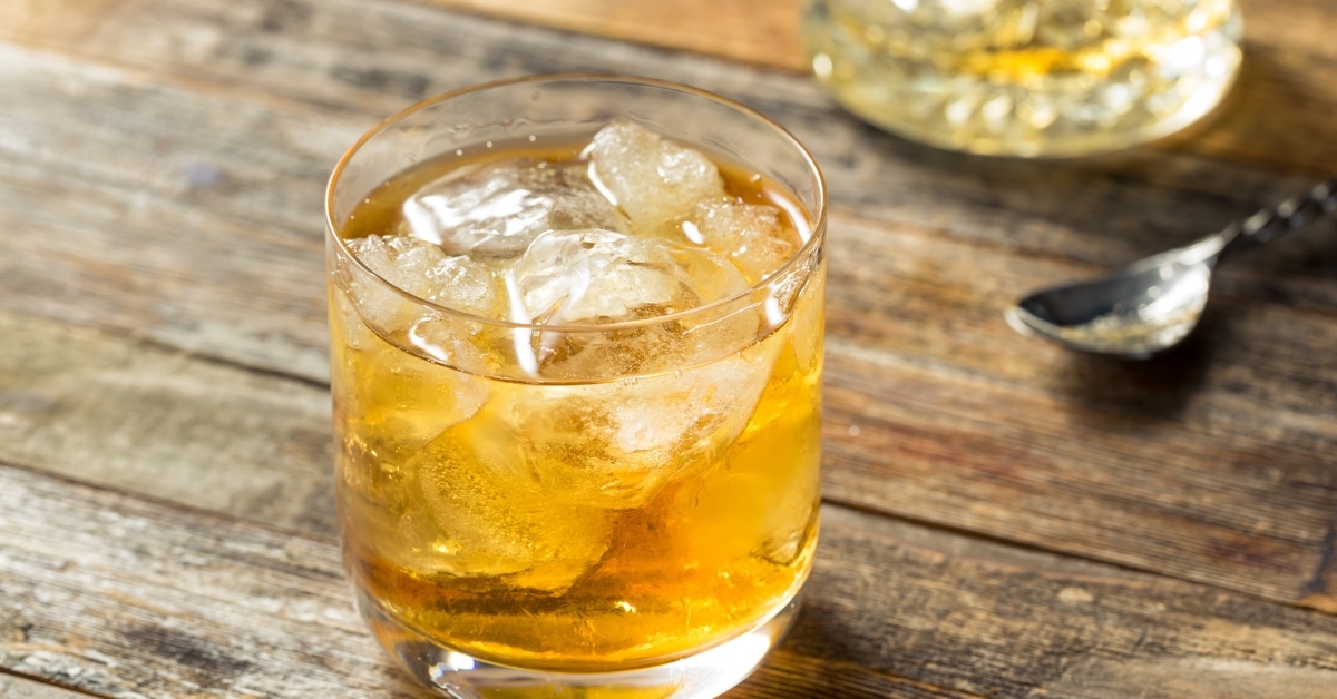 Old fashioned glass with Godfather cocktail served with ice.