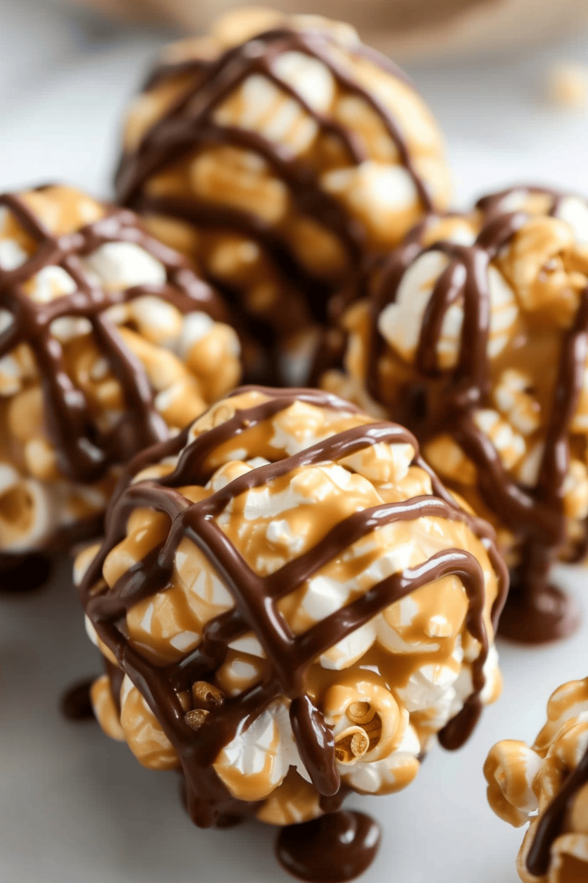 Homemade Peanut Butter Popcorn Balls drizzled with chocolate