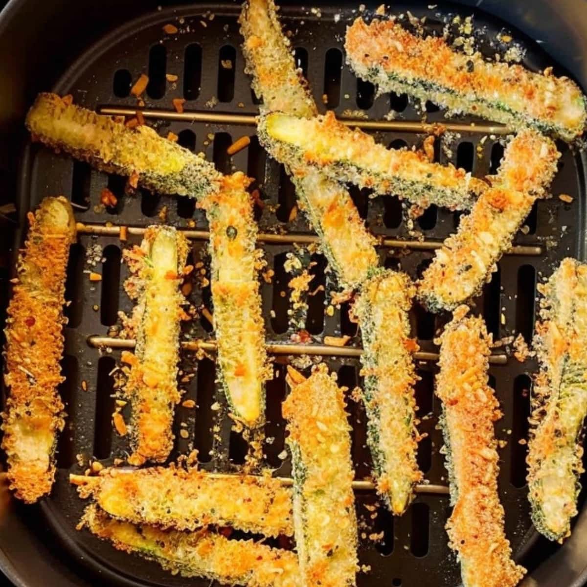 Zucchini fries inside an air fryer.