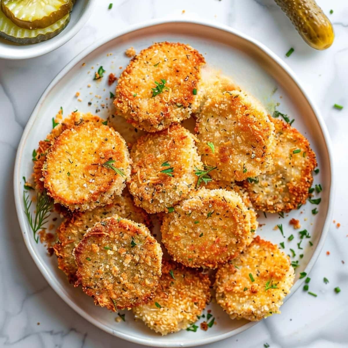 Bunch of breadcrumbs coated dill pickles in a plate.