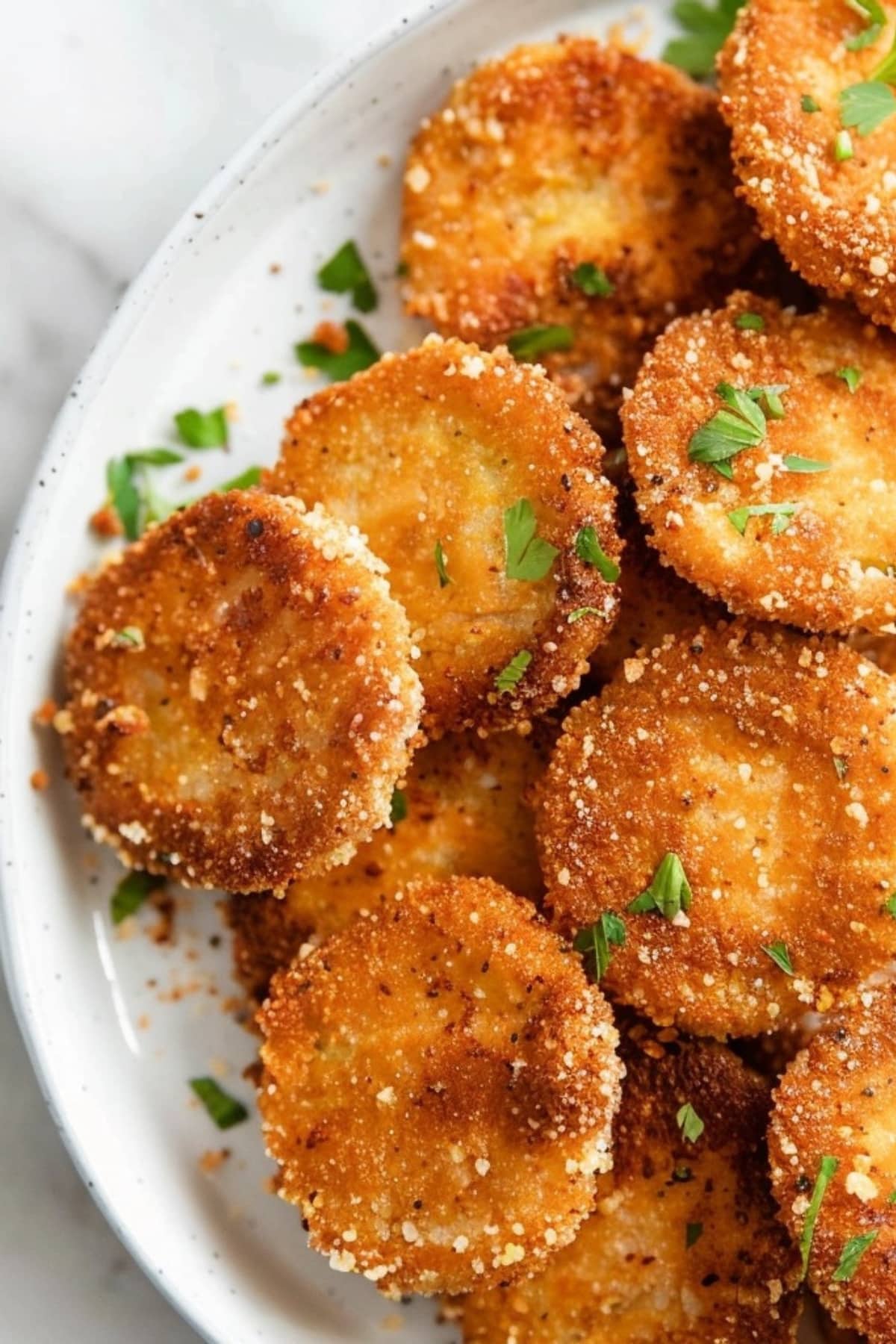 Bunch of air fryer dill pickles in a white plate