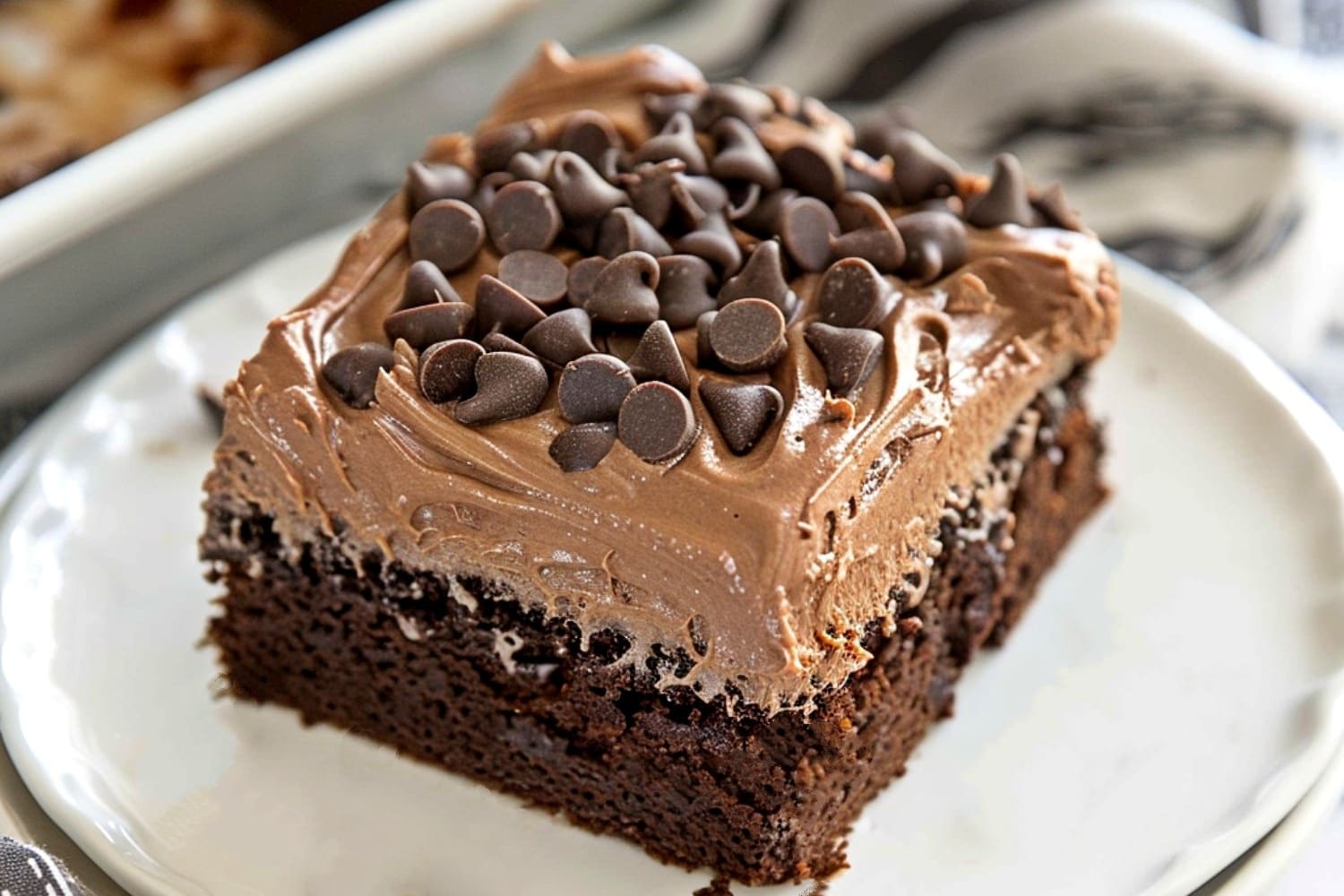 Chocolate poke cake topped with creamy mousse in a white plate