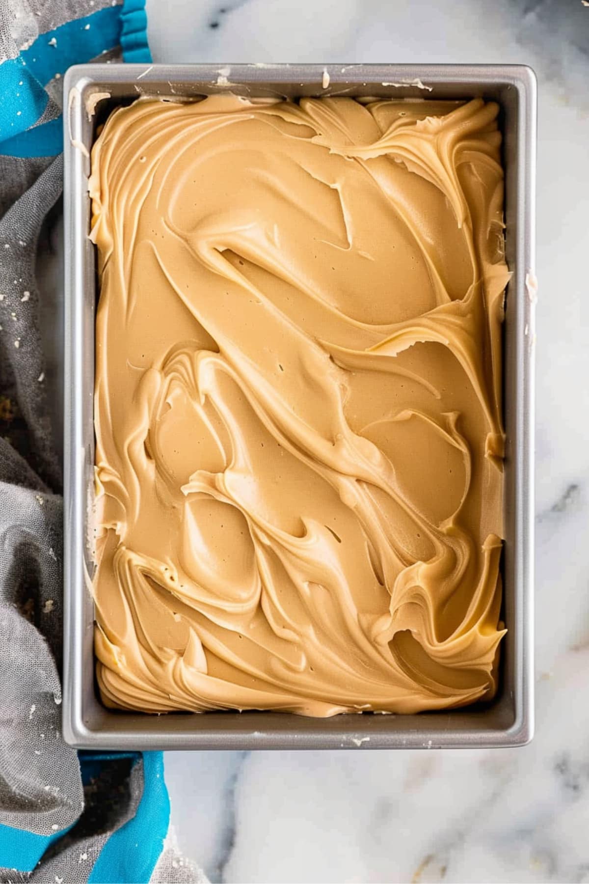 Peanut butter sheet cake in a 9x13 inch baking pan on a white marble table