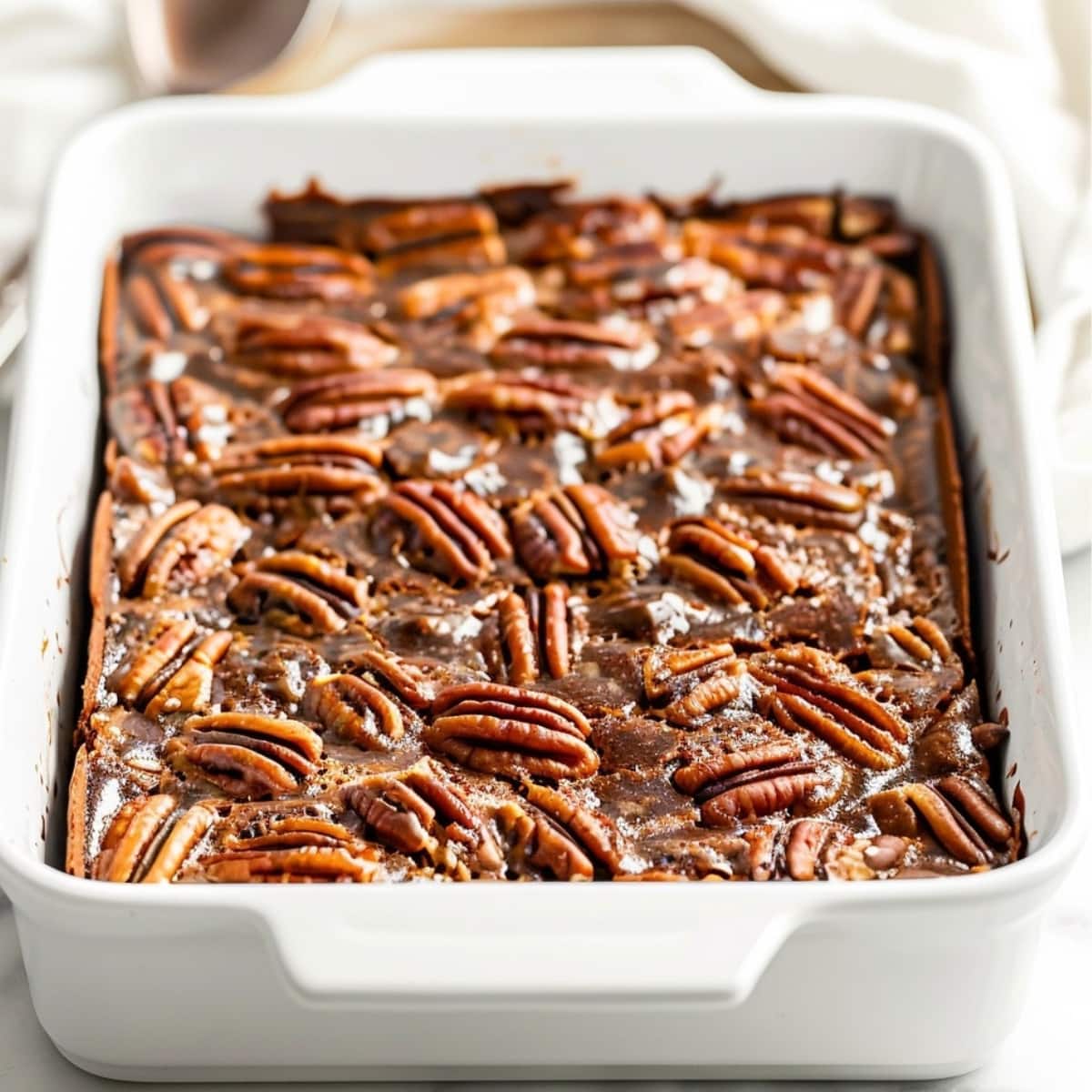 Pecan pie bar dessert in a white baking dish.