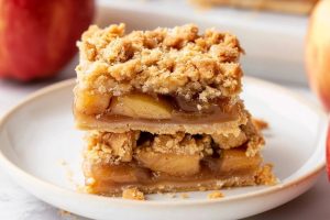 Apple bar slices stack on each other served on a white plate.