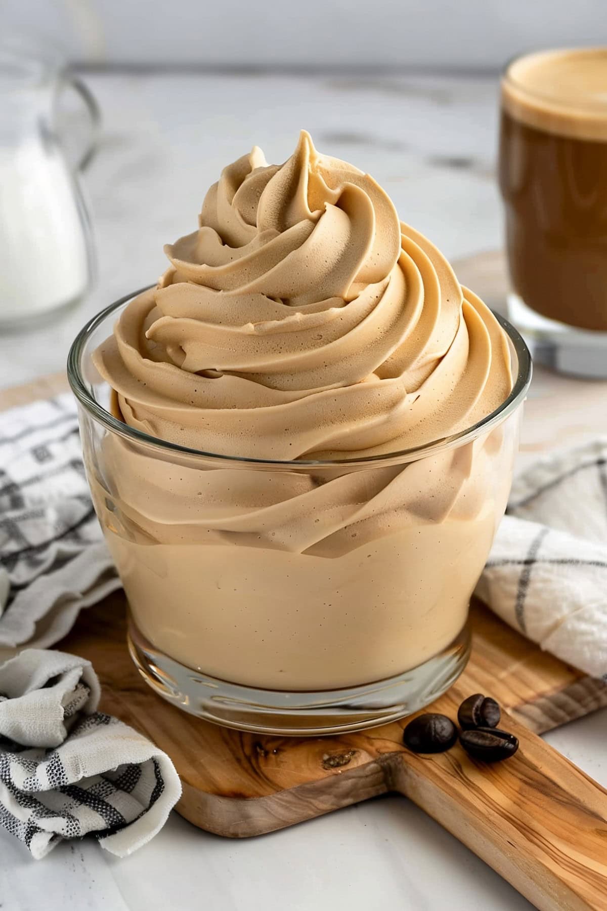 Heavenly coffee whipped cream in a glass with a coffee in the background